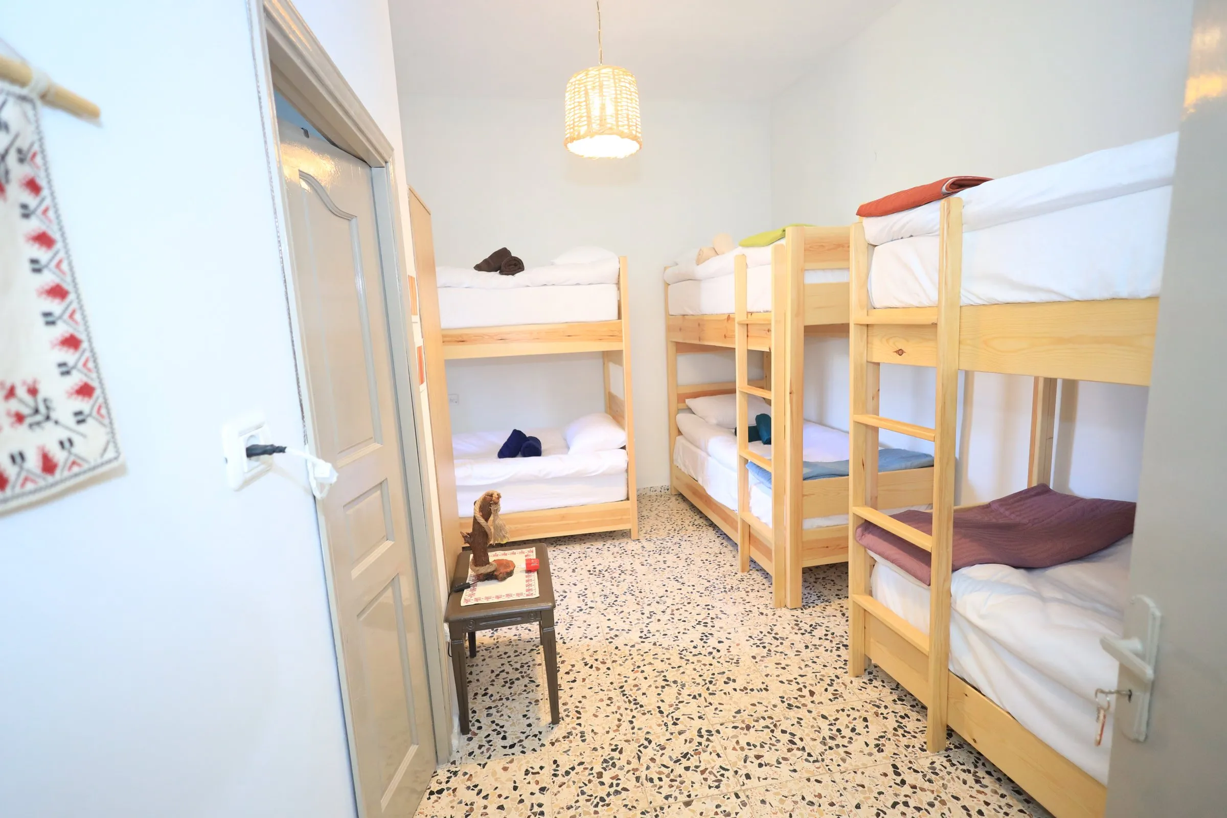 The shared room seen from the door, with embroidered wall hanging